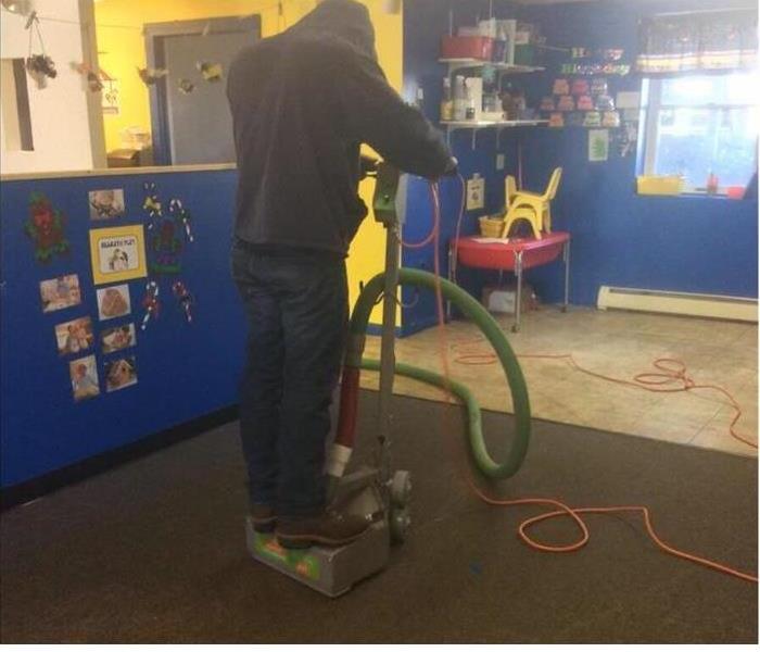 One of our techs using a water extractor machine to extract water from the wet carpet in this preschool